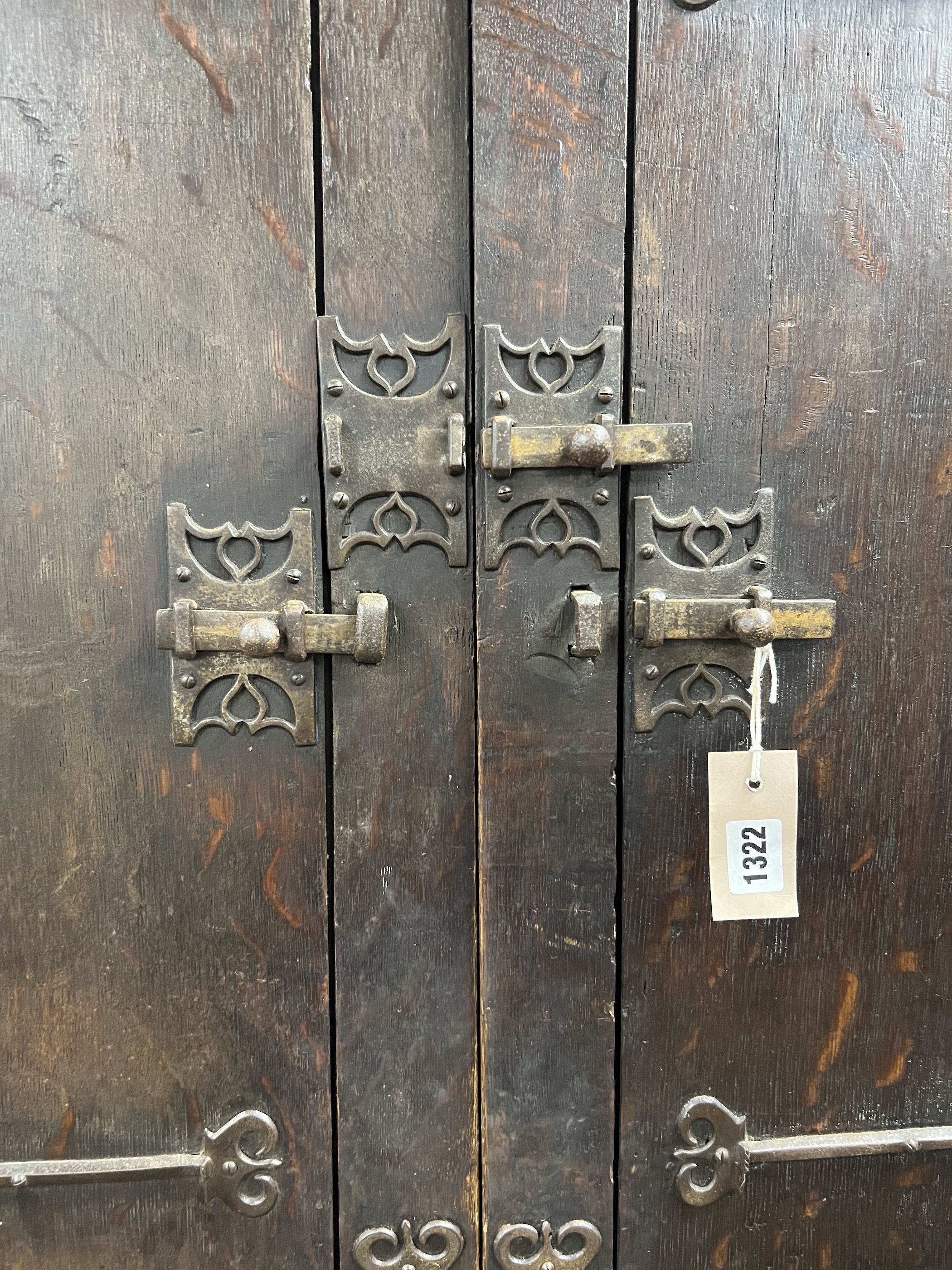 A pair of 16th century German or Netherlandish oak and wrought iron strapwork window shutters, later mounted on a cupboard, width 156cm, depth 57cm, height 210cm